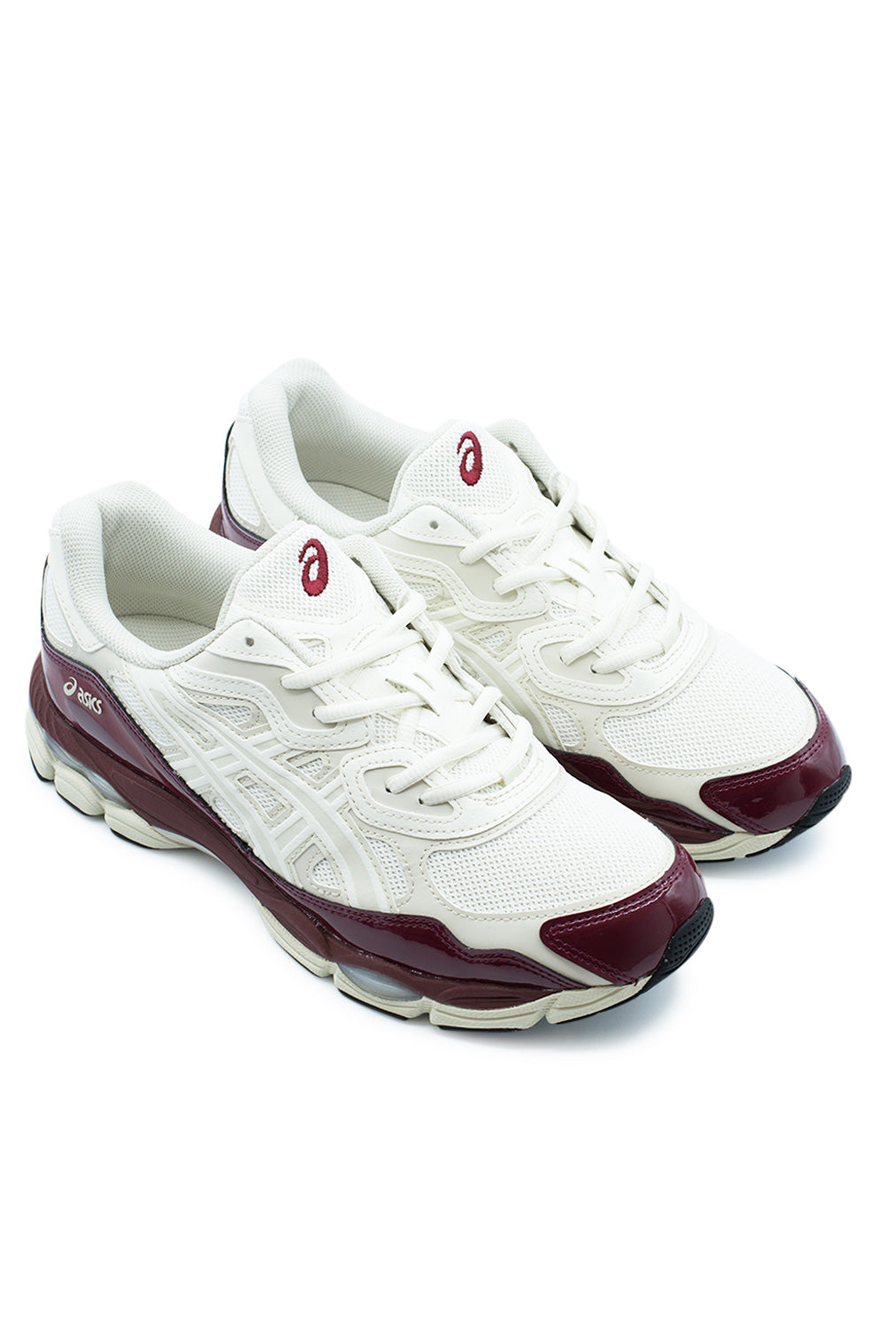 Elevated three-quarter studio angle of the Asics Gel-NYC in Cream / Antique Red, showcasing the fusion of Gel-Nimbus 3 and Gel-MC Plus V heritage lines, glossy wine red patent trim, and chunky lifestyle running silhouette