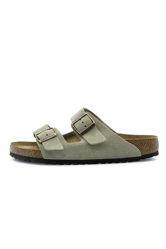 Lateral side profile view of the Birkenstock Arizona BS sandal in Taupe suede, featuring two wide adjustable suede straps with copper metal pin buckles, a natural cork-latex footbed layer, and a dark brown EVA outsole.