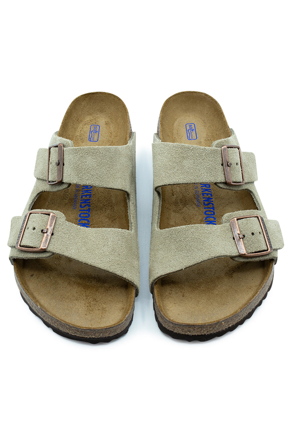 Top-down perspective of a pair of Birkenstock Arizona BS Soft Footbed sandals in Taupe, highlighting the velvety suede upper, adjustable copper buckles, and contoured suede-lined insoles with blue BIRKENSTOCK Soft Footbed branding.