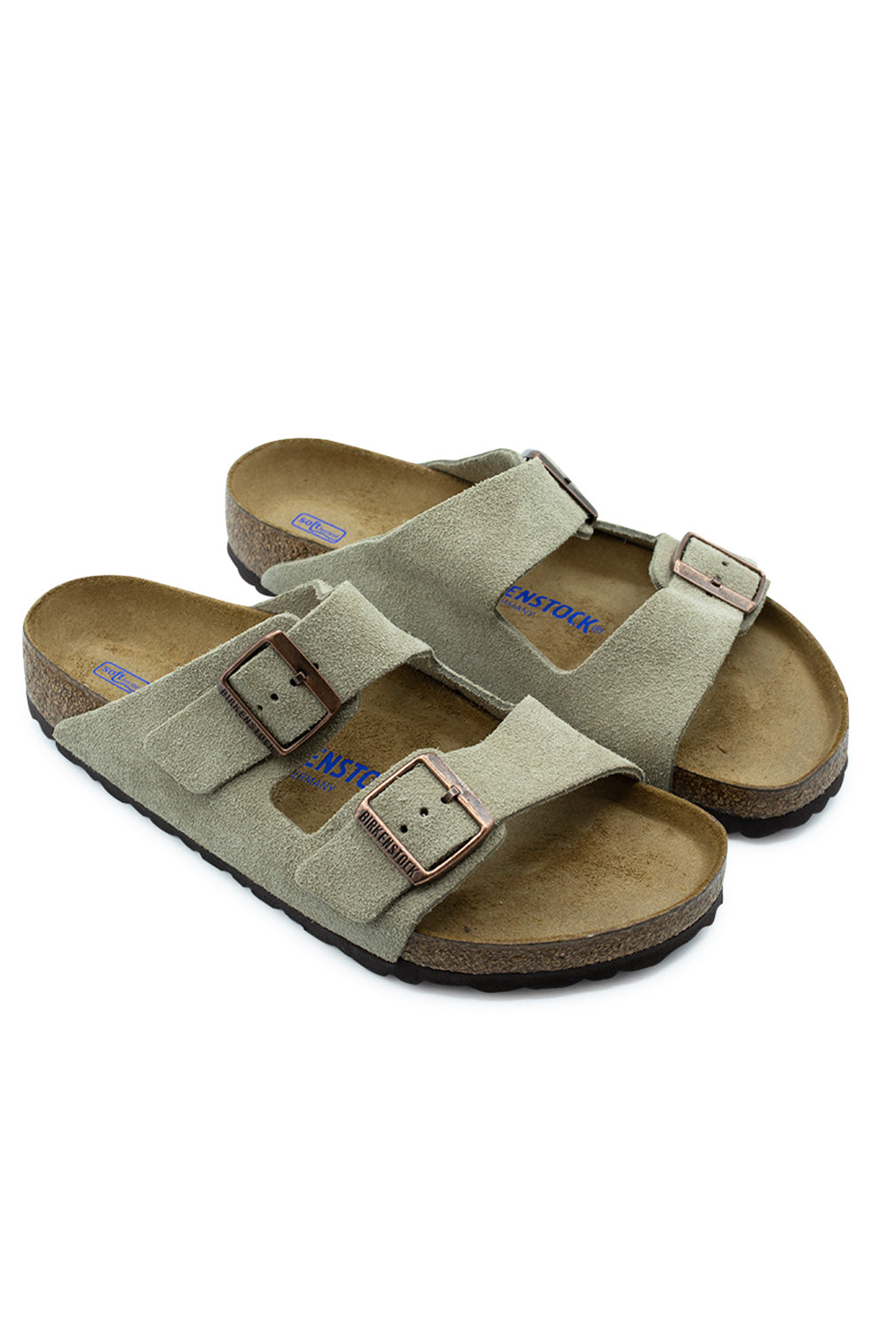 Three-quarter perspective studio shot of the Birkenstock Arizona BS Taupe suede sandals, showcasing the classic two-strap design, bronze metal hardware, and ergonomic cork footbed structure.
