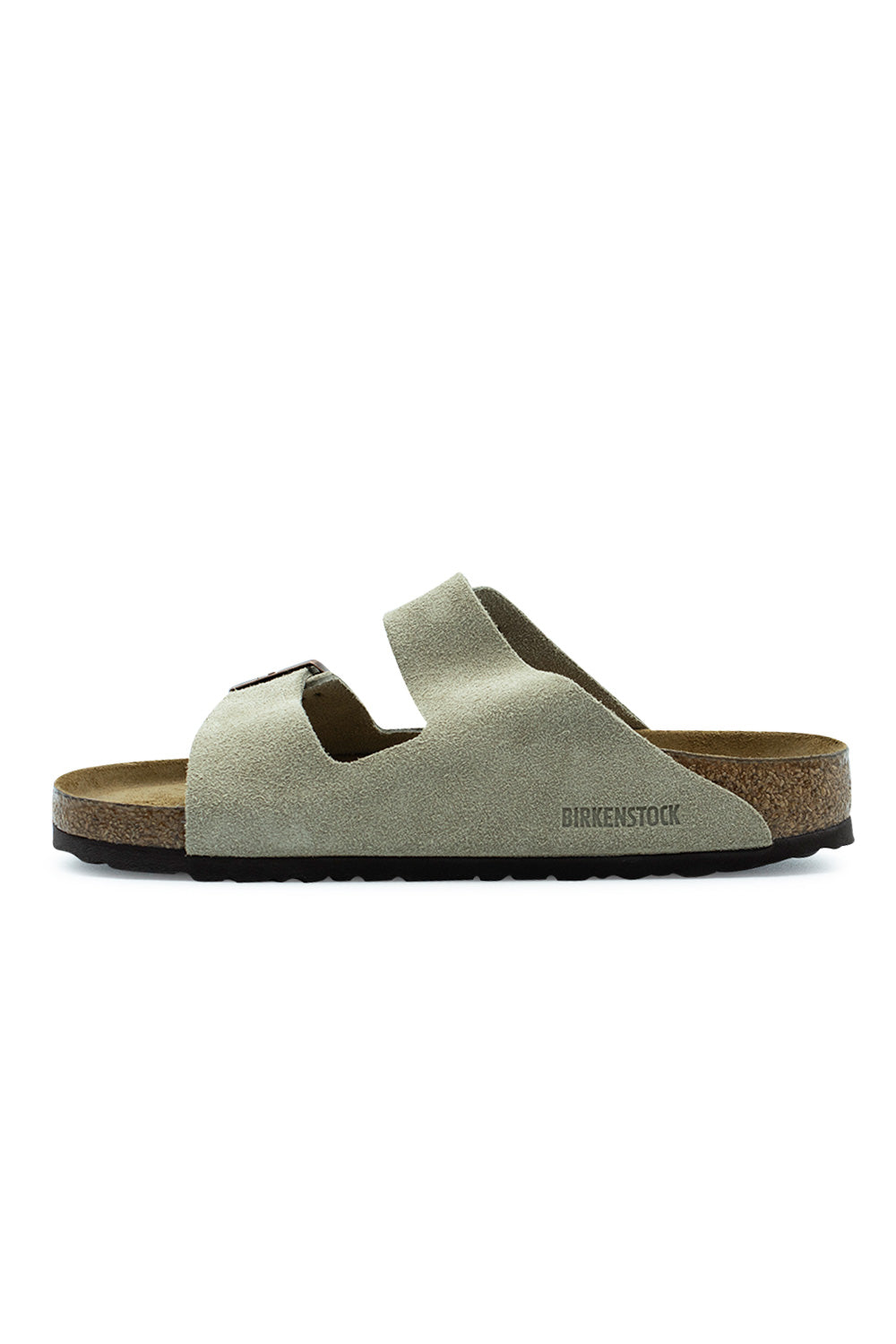 Medial side profile view of the Birkenstock Arizona BS Taupe sandal, illustrating the inner suede upper panel with embossed BIRKENSTOCK logo lettering along the side and the dark EVA sole edge.