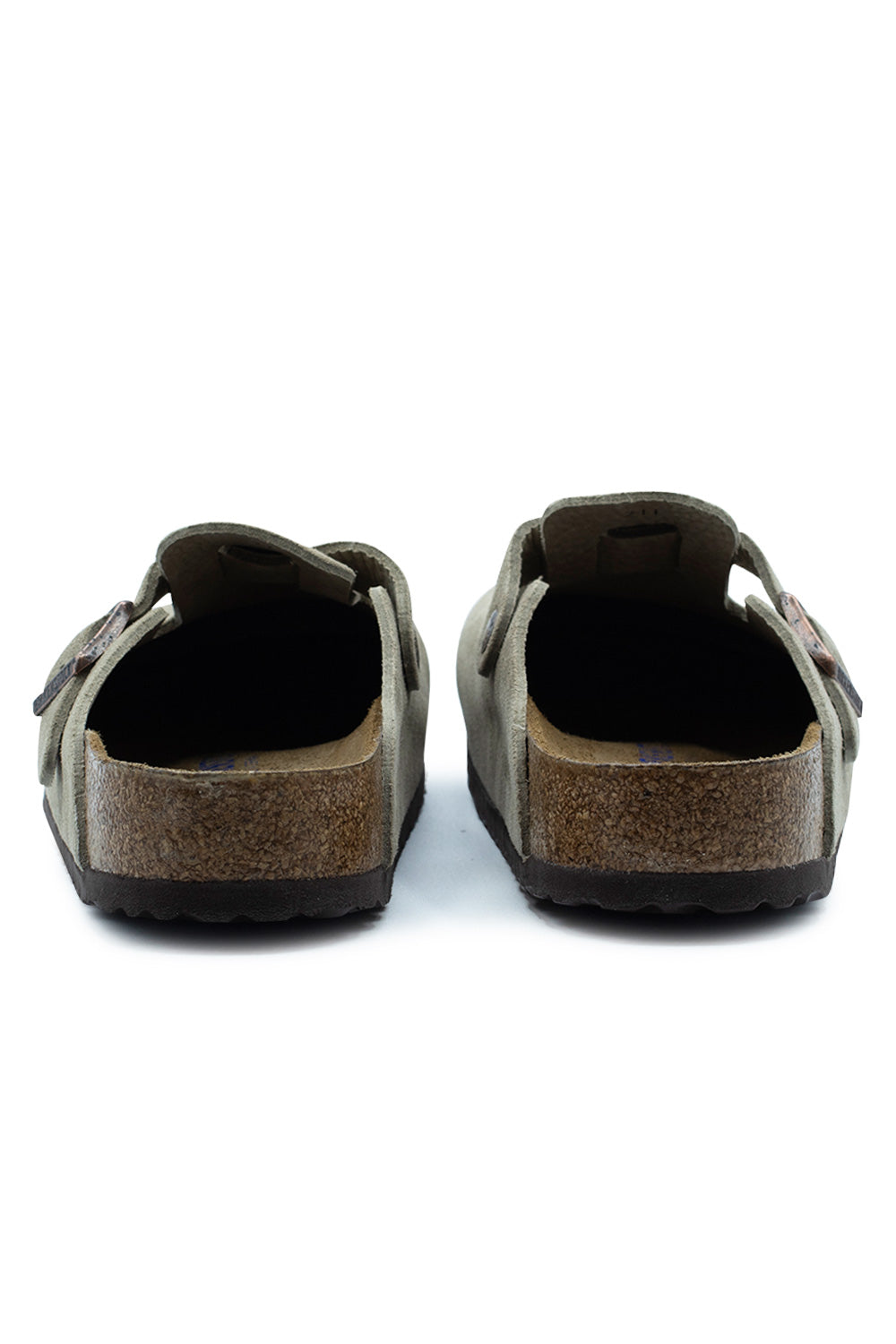 Rear view of the open heels of the Birkenstock Boston BS Taupe suede clogs, displaying the anatomical cork heel cups, raised edge borders, and dark brown treaded EVA sole layer.
