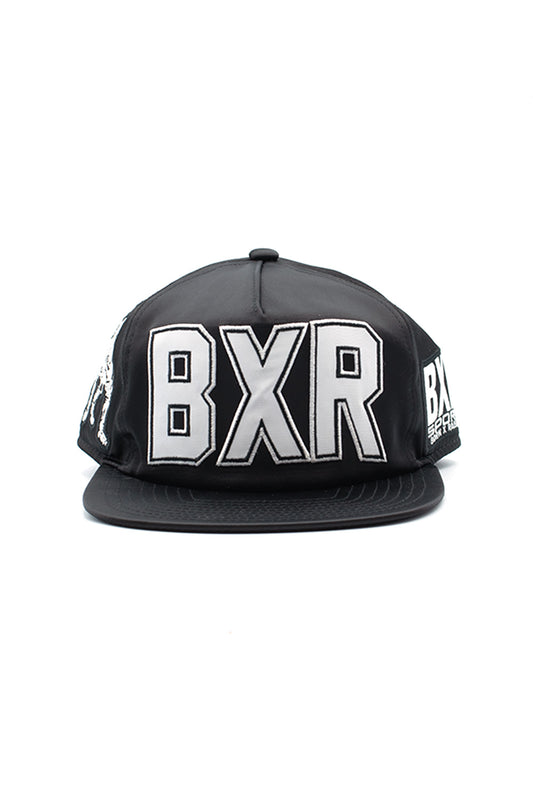 Front view of the black shiny Born X Raised Boxing Hat, featuring large silver-white embroidered BXR letters stitched on the front crown.
