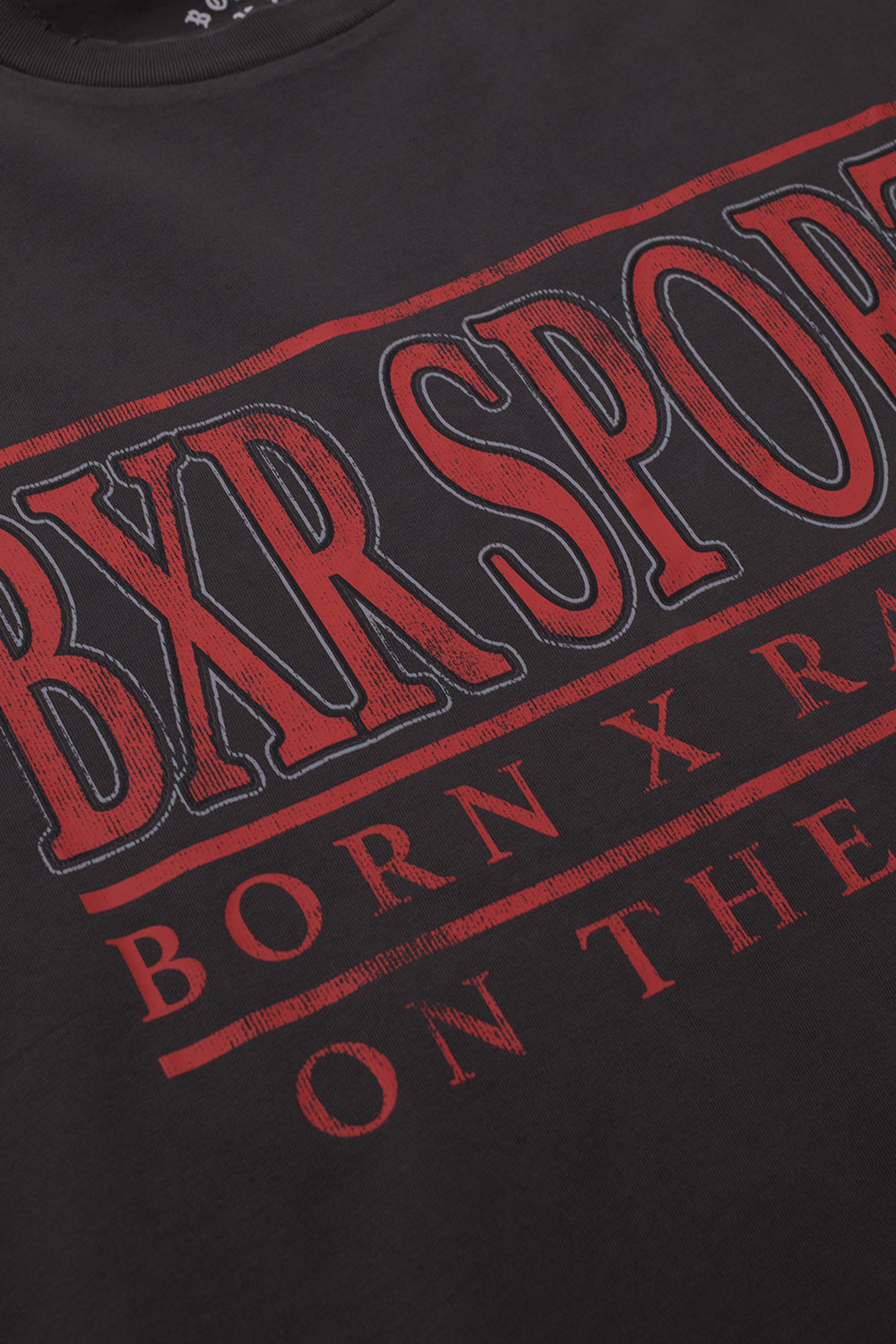 Close-up detail of the red screen-printed BXR SPORT text on the front of the heavy 6.5 oz vintage black cotton fabric.