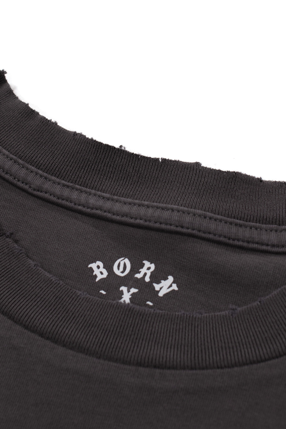 Macro shot of the ribbed collar on the Born X Raised tee, showcasing the distressed frayed edge detailing and printed neck tag.