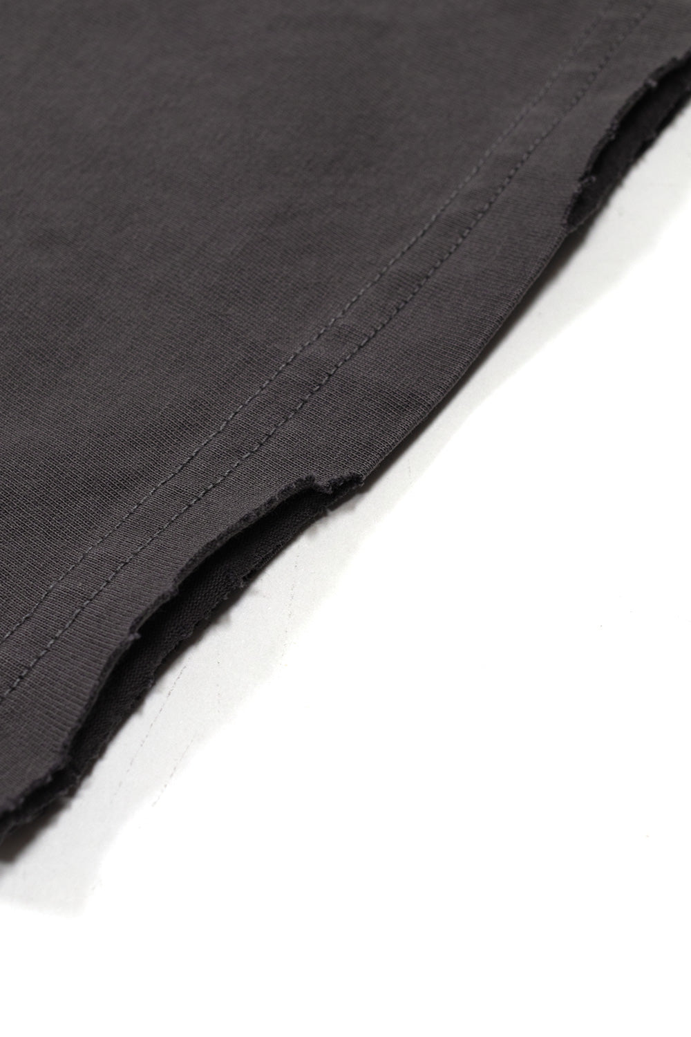 Close-up view of the bottom hem on the Born X Raised University T-shirt, displaying the custom distressing and frayed edge finish.