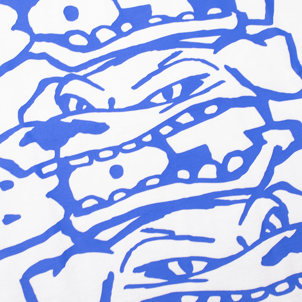 Detailed macro studio close-up of the front screen print on the white BoTT Bottweiler T-Shirt, capturing the bold cobalt blue graphic linework detailing the sharp eyes, bared teeth, and playful aggression of the stacked cartoon dog illustration against smooth white cotton fabric.