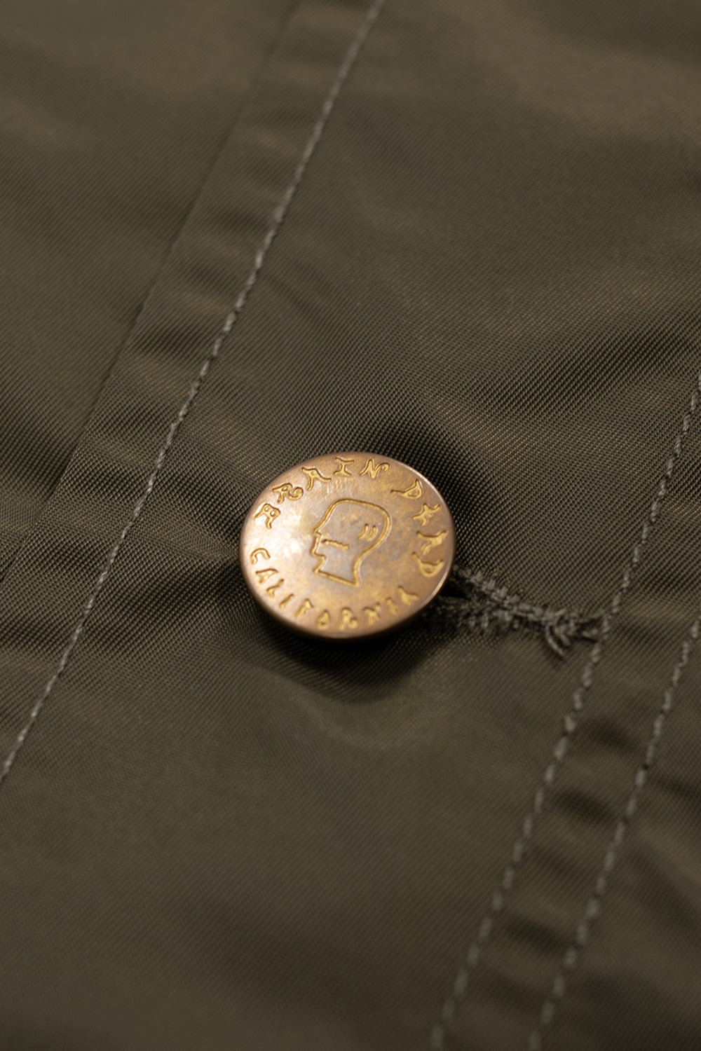 Side view of Brain Dead Cropped Chore Jacket Green, contemporary chore-style jacket with corduroy collar, mesh pockets, and water-resistant shell.