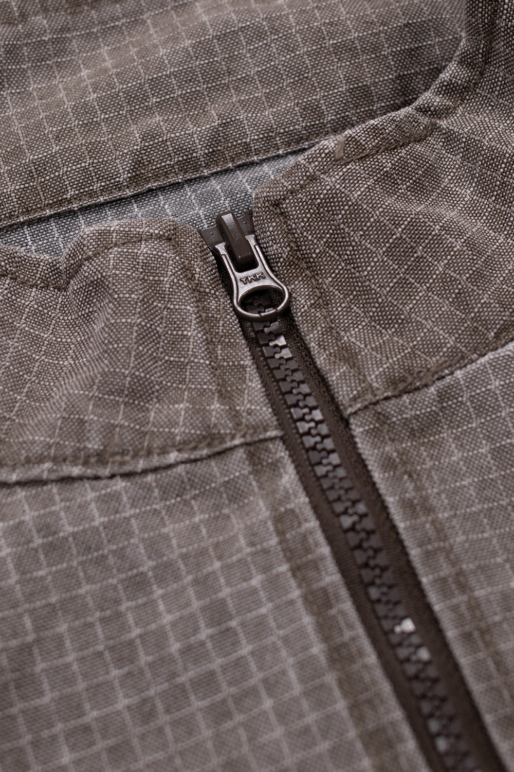 Close-up of Brain Dead Washed Ripstop Equipment Half Zip Brown jacket showing durable YKK half-zip front closure and washed ripstop nylon fabric texture