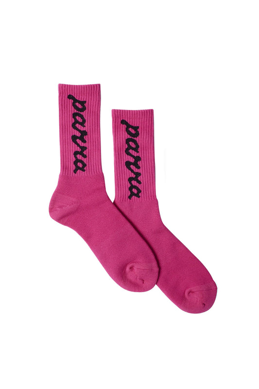 Pair of vibrant hot pink By Parra Lowercase Scriptlogo Crew Socks laid flat, crafted in Japan from a premium cotton blend, featuring vertical black woven cursive Parra lettering along the ribbed ankle collar.