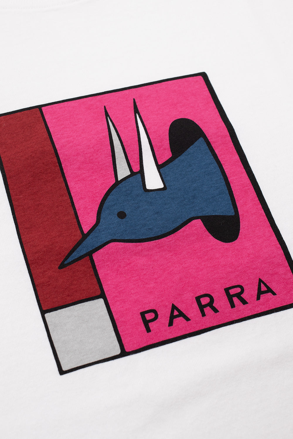 Detailed close-up shot of the water-based screen-printed graphic on the chest of the By Parra tee, illustrating Pieter Janssen's signature blue bird creature mounted like a trophy inside a pink geometric box above black PARRA lettering.