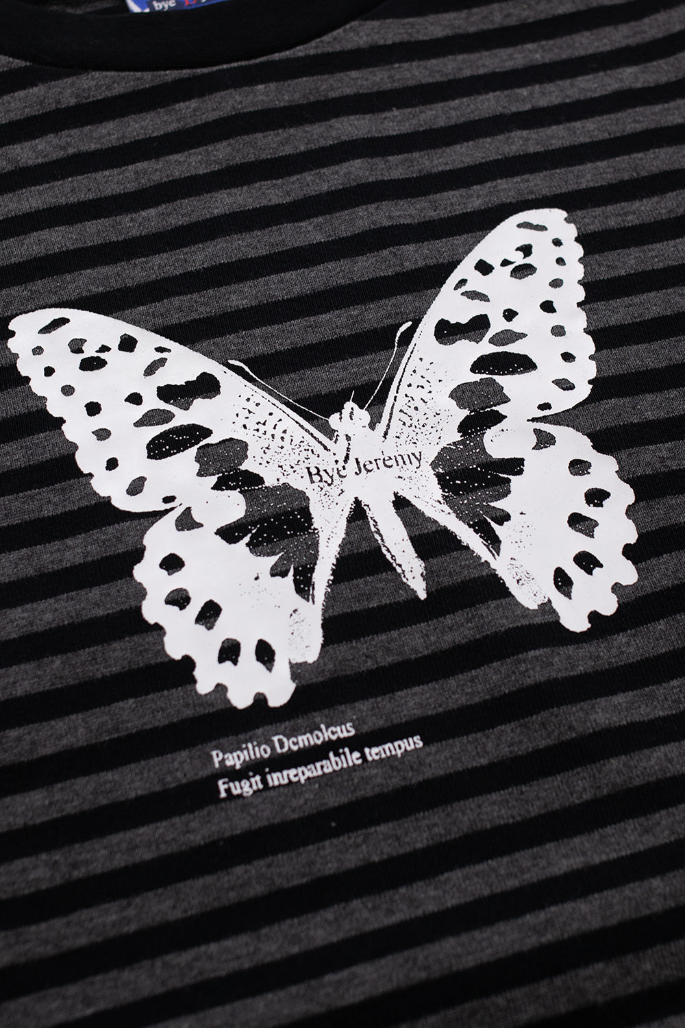 Close-up of the Bye Jeremy white butterfly screen print on the black striped longsleeve, showcasing detailed chest graphic and premium heavy cotton texture.