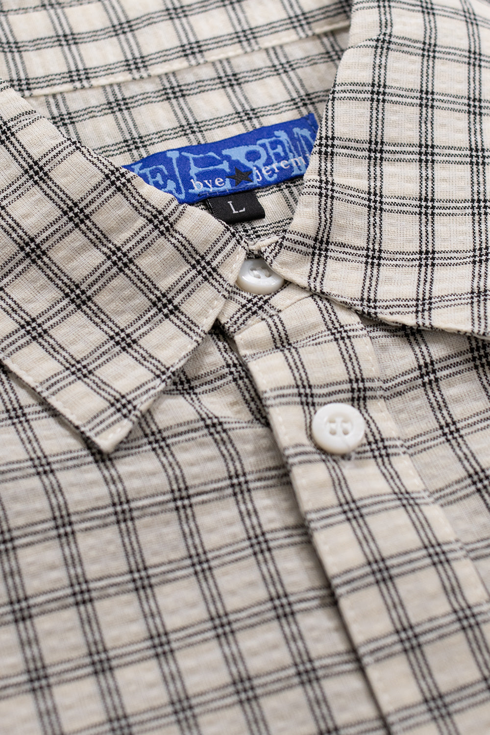Wide-fitted Bye Jeremy Supper Button Up Shirt made from soft 100% cotton, showcasing a summit white grid check print and signature black butterfly logo patch on the chest.