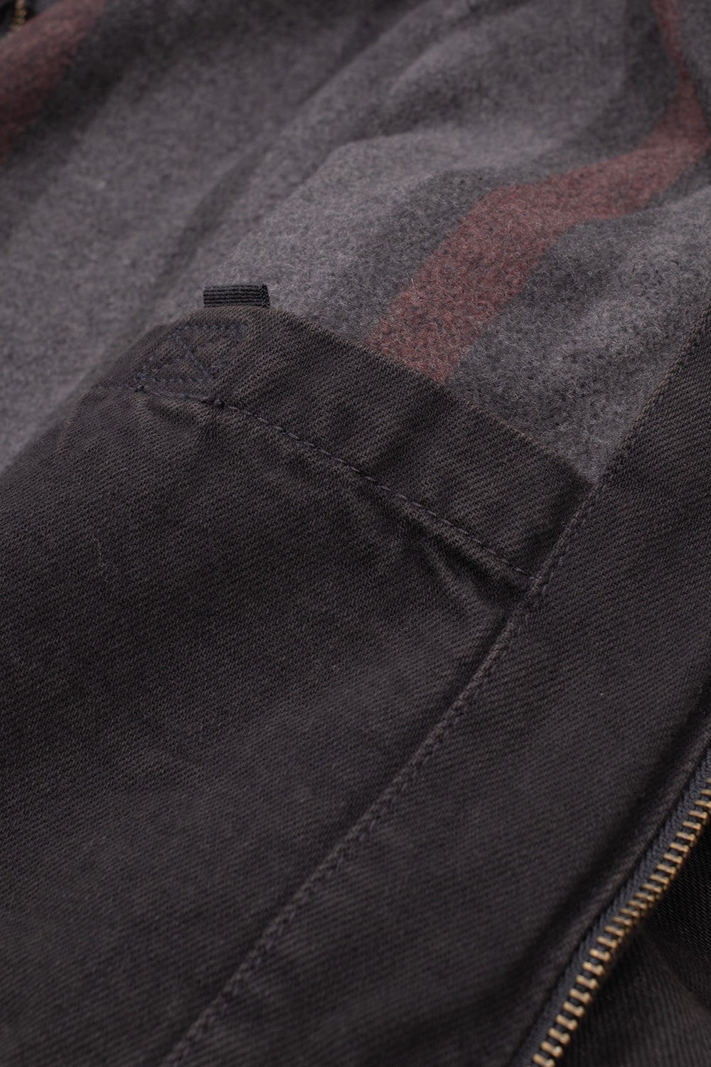 Interior view of the Carhartt WIP OG Detroit Jacket, revealing the internal chest patch pocket with reinforced bar-tack stitching alongside the warm striped wool-blend blanket body lining.