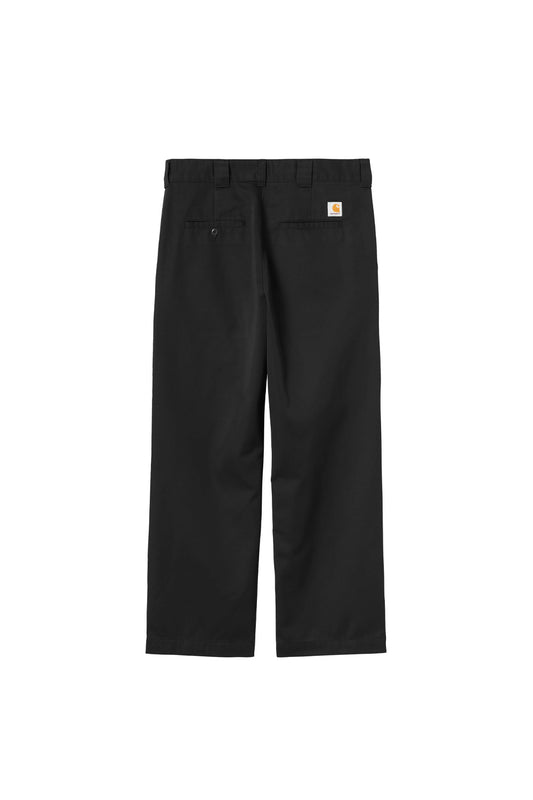 Rear flat lay view of the Carhartt WIP OG Master Pant in Black Rinsed, displaying the relaxed straight-leg workwear cut in heavyweight poly-cotton twill, wide belt loops, two horizontal back welt pockets with left button closure, and the iconic white and golden-yellow square woven Carhartt logo patch on the right pocket.