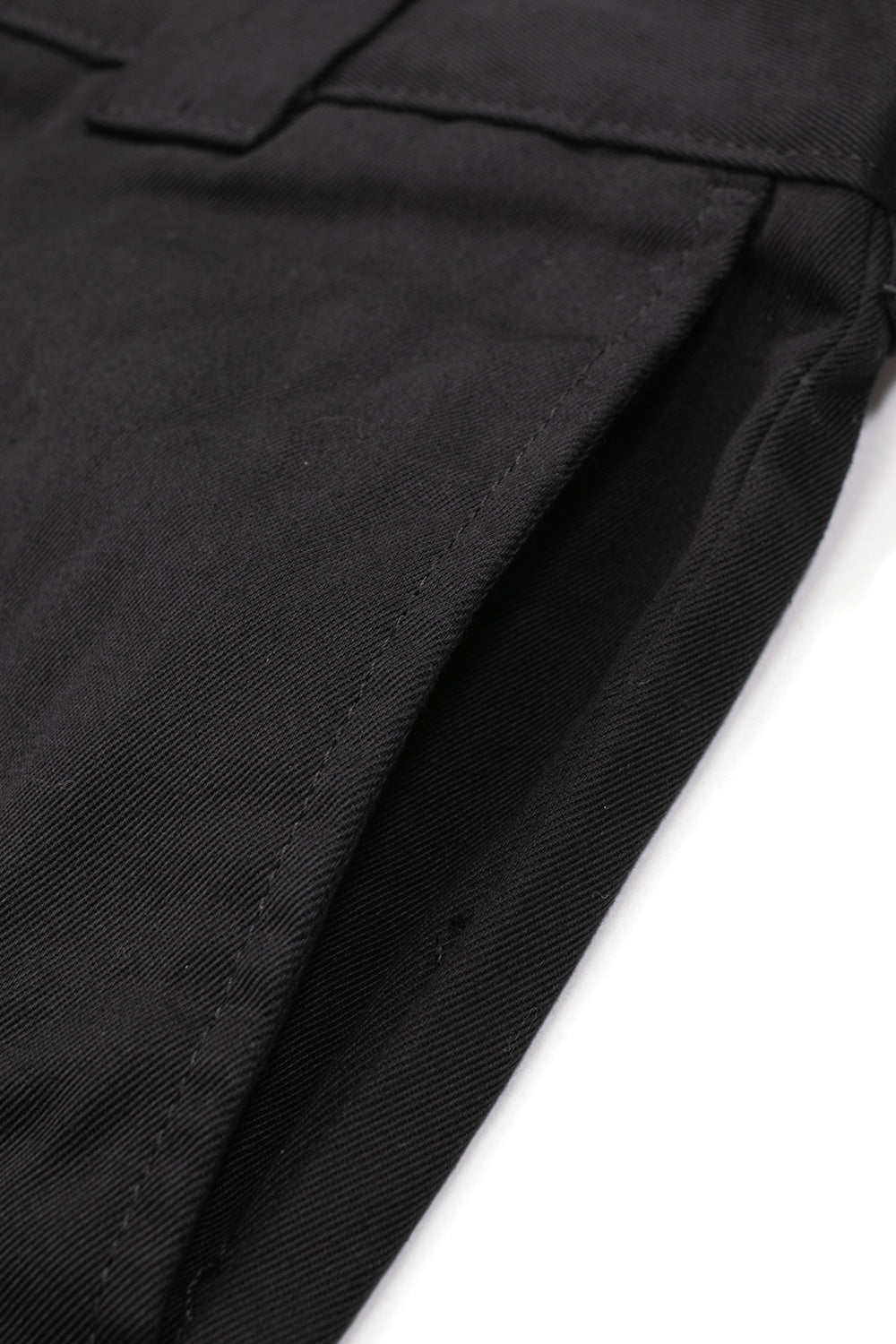 Extreme close-up shot of the side seam slash hand pocket on the black Carhartt WIP OG Master Pant, showcasing the dense diagonal weave texture and durable construction of the rinsed poly-cotton twill workwear fabric.