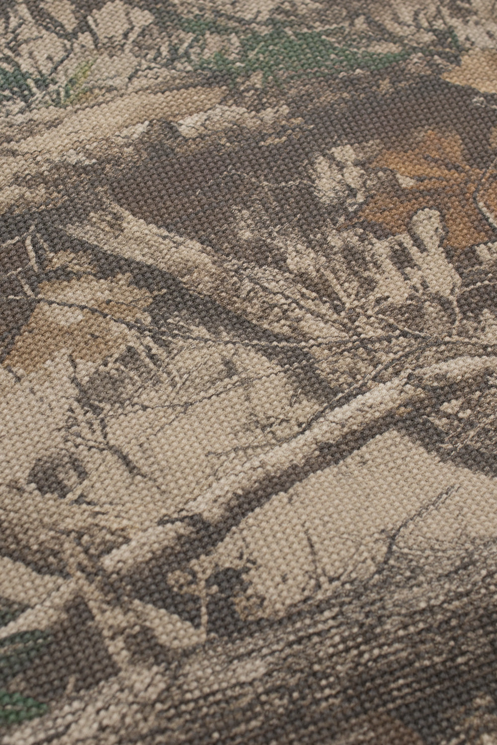 Macro texture shot of the premium 370-gram 100% cotton waffle knit material, highlighting the detailed weave and the earthy tones of the all-over tree camo print.