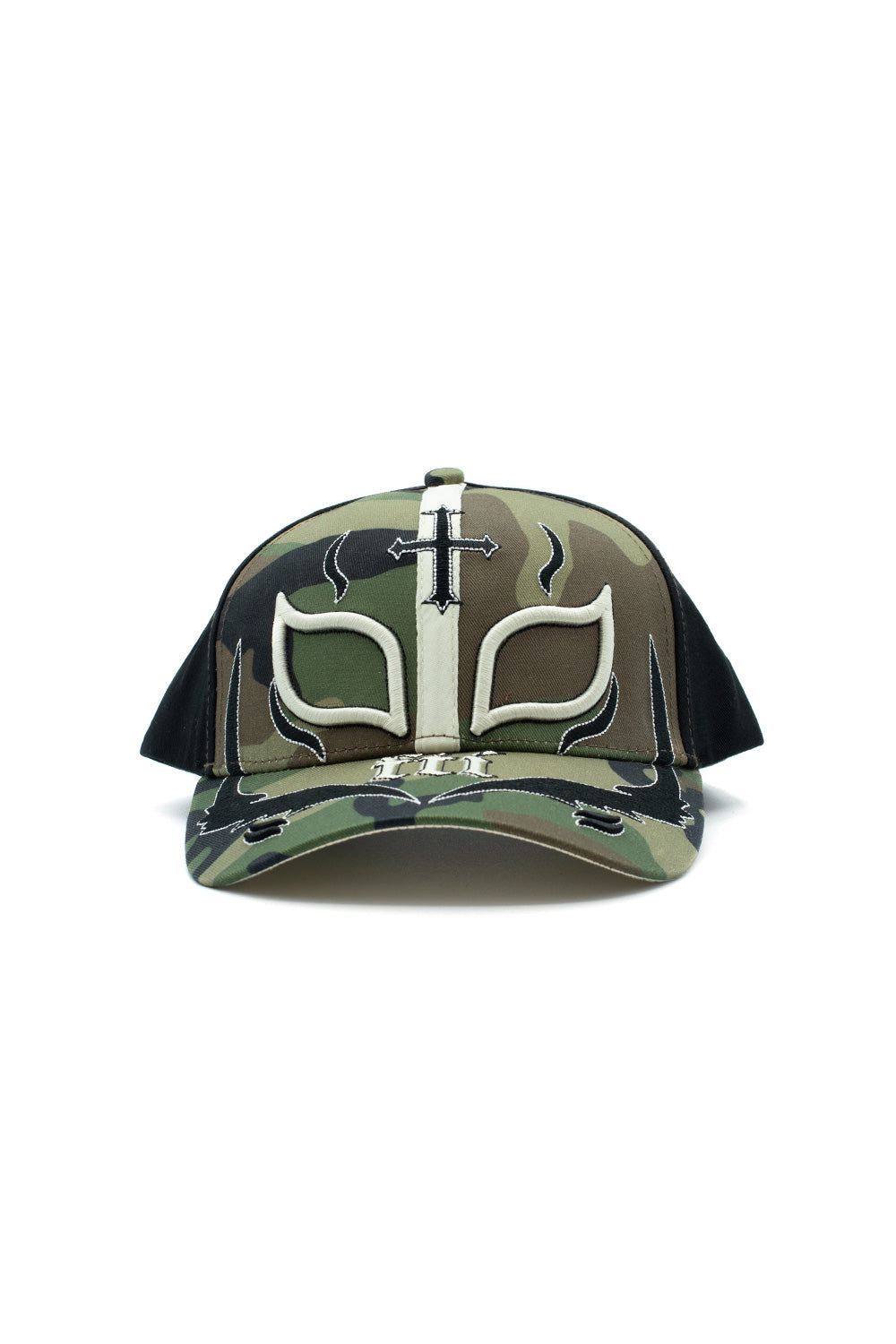 Front view of the Fuck This Industry Mystery Hat in woodland camouflage and black, featuring heavy 3D-embroidered cream and black Mexican lucha libre wrestling mask detailing across the front crown, a vertical center strap with a Gothic cross, black side panels, and a distressed curved camouflage brim with "fti" Old English embroidery and tribal flame graphics