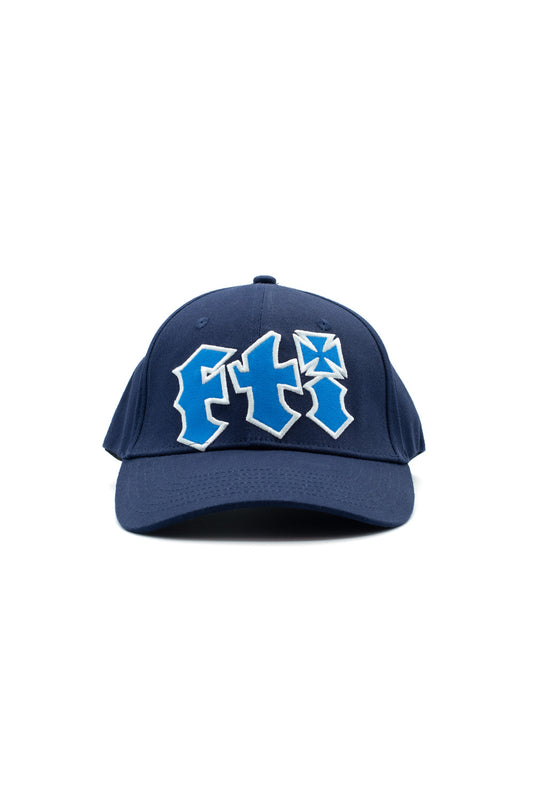 Front studio view of the Fuck This Industry Sorry Hat in navy blue, crafted from 100% cotton twill, featuring a curved brim and a large centered 3D puff embroidery of the stylized "FTI" acronym in bright royal blue with a thick white border, incorporating an iron cross motif into the letter I