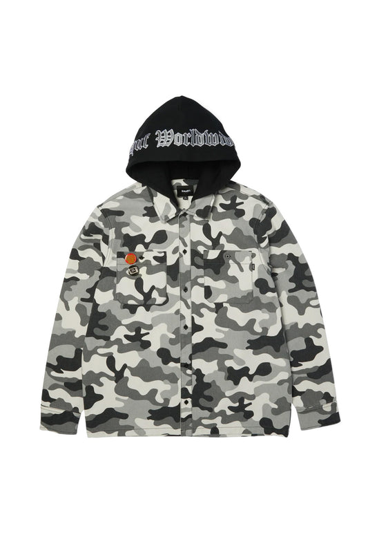Front view of the HUF Olympia Camo Hooded Overshirt, constructed from durable 324gsm duck canvas in an urban grey, black, and white camouflage print, featuring a boxy button-down silhouette, an integrated black fleece hood with white Old English embroidered branding, two buttoned flap chest pockets, and two punk pin badges on the right pocket flap.