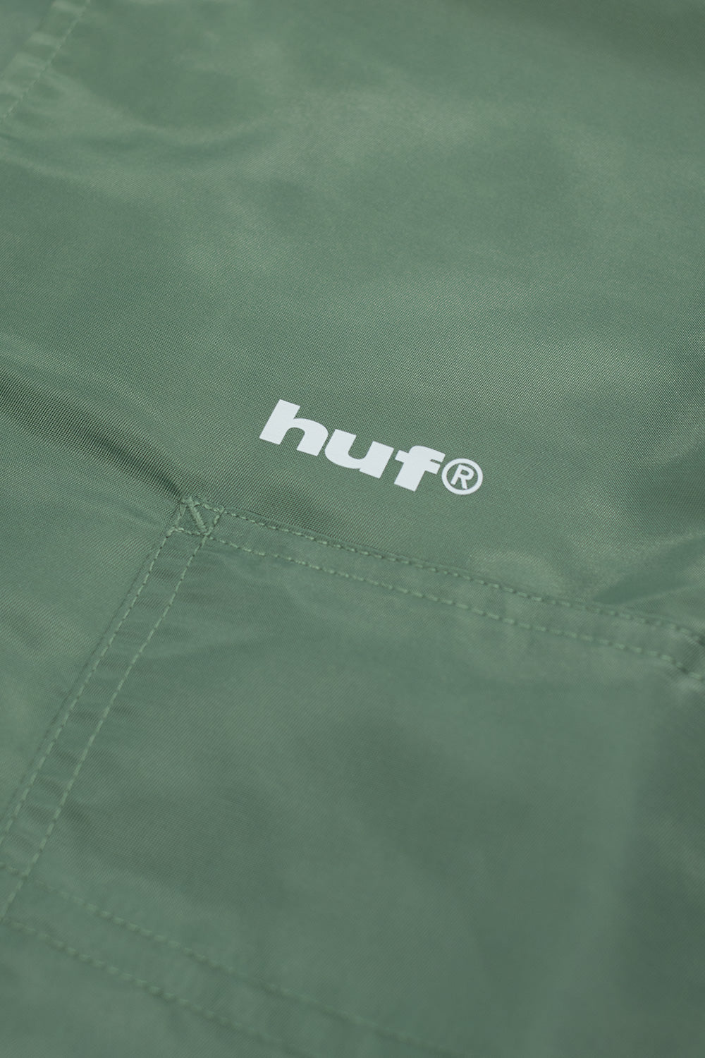 HUF x Thrasher Forest Green coaches jacket, lightweight nylon shell with vintage logo artwork, press buttons, and full polyester lining.