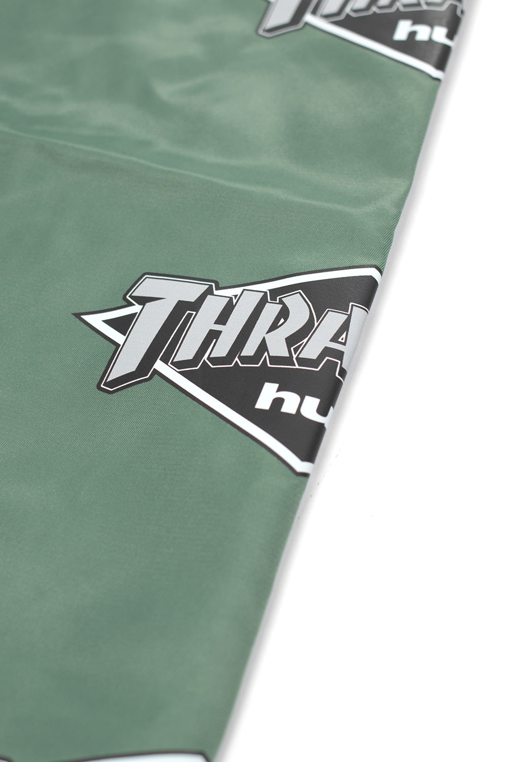 Unisex HUF Thrasher Logo Jacket in Forest Green, capsule collection piece with printed graphics, dual pockets, and iconic skate collaboration styling.