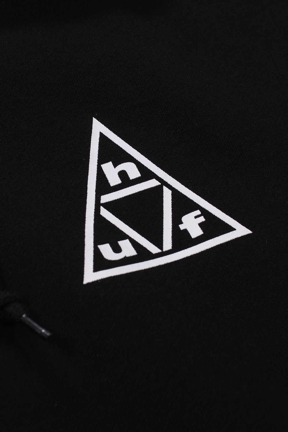 Detailed view of the HUF Triple Triangle chest artwork featuring crisp white logo printing on premium heavyweight black fleece fabric