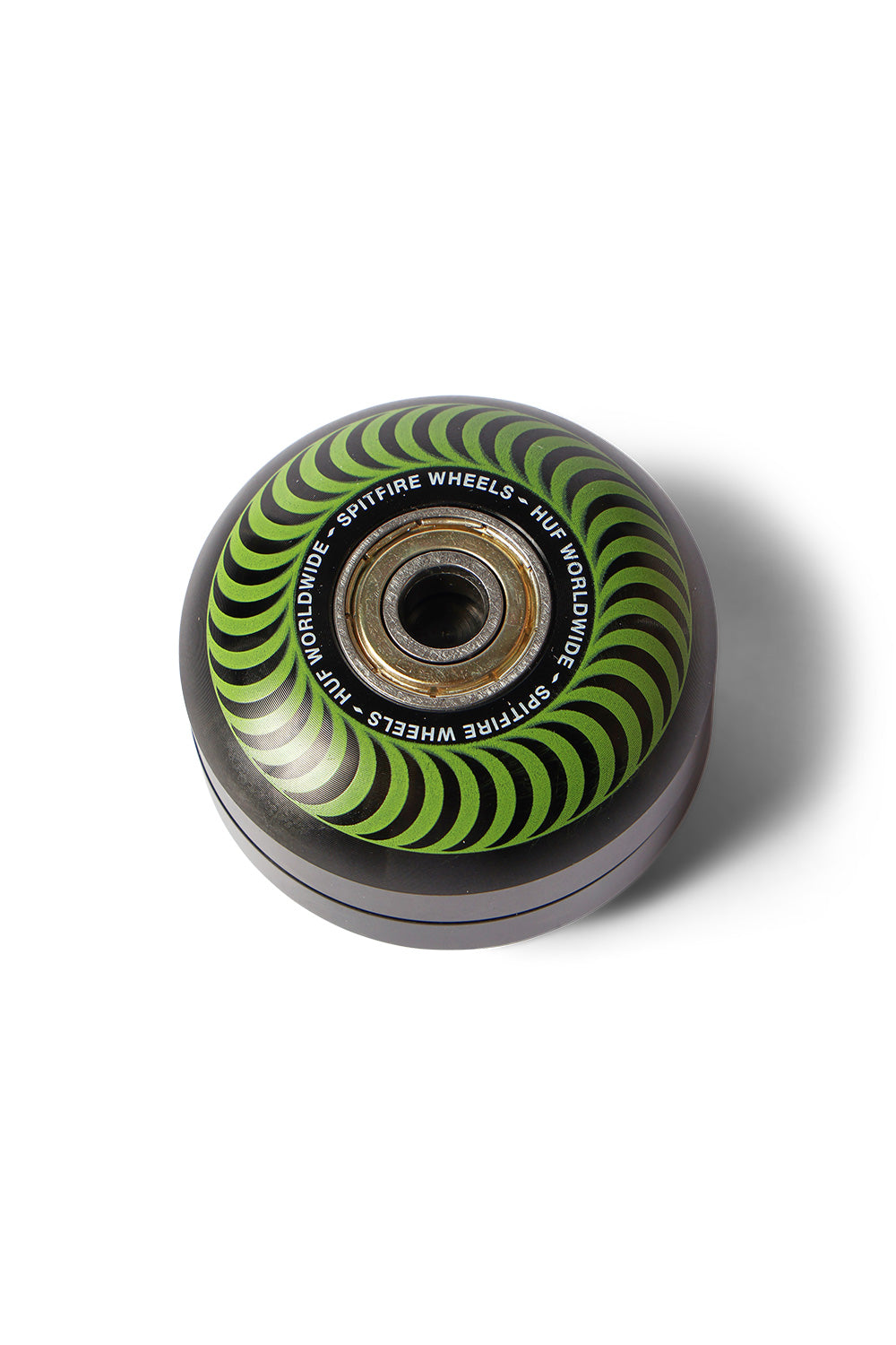 Top view of the assembled HUF X Spitfire Classic Grinder in Green, designed in the realistic shape of a skateboard wheel featuring a green Spitfire swirl graphic, HUF Worldwide branding, and an authentic center skateboard bearing.