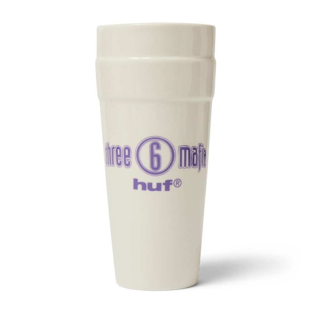Reverse studio view of the white glazed Huf X Three 6 Mafia Ceramic Double Cup, showcasing the iconic purple printed Three 6 Mafia logo encircled around the numeral 6, positioned above a clean purple lowercase "huf®" brand wordmark.