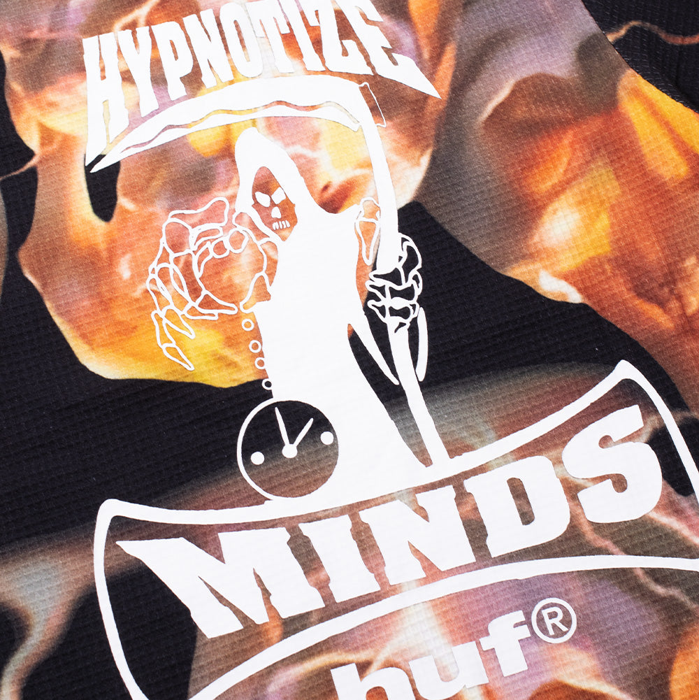 Macro studio perspective of the back print on the Huf X Three 6 Mafia Torched Longsleeve Thermal, showcasing the crisp white screen-printed Hypnotize Minds reaper holding an hourglass clock over the arched "MINDS" and "huf®" typography on the waffle-weave fabric.