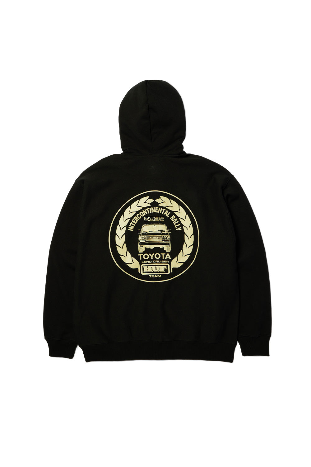 Back flat lay view of the black Huf X Toyota Land Cruiser Heavyweight FZ Hoodie, displaying the broad drop-shoulder construction, ribbed hem and cuffs, and an oversized cream-colored circular back print featuring an illustrated Toyota Land Cruiser 4x4 front view encircled by a laurel wreath with "INTERCONTINENTAL RALLY 2026", "TOYOTA LAND CRUISER", and "HUF TEAM" typography.