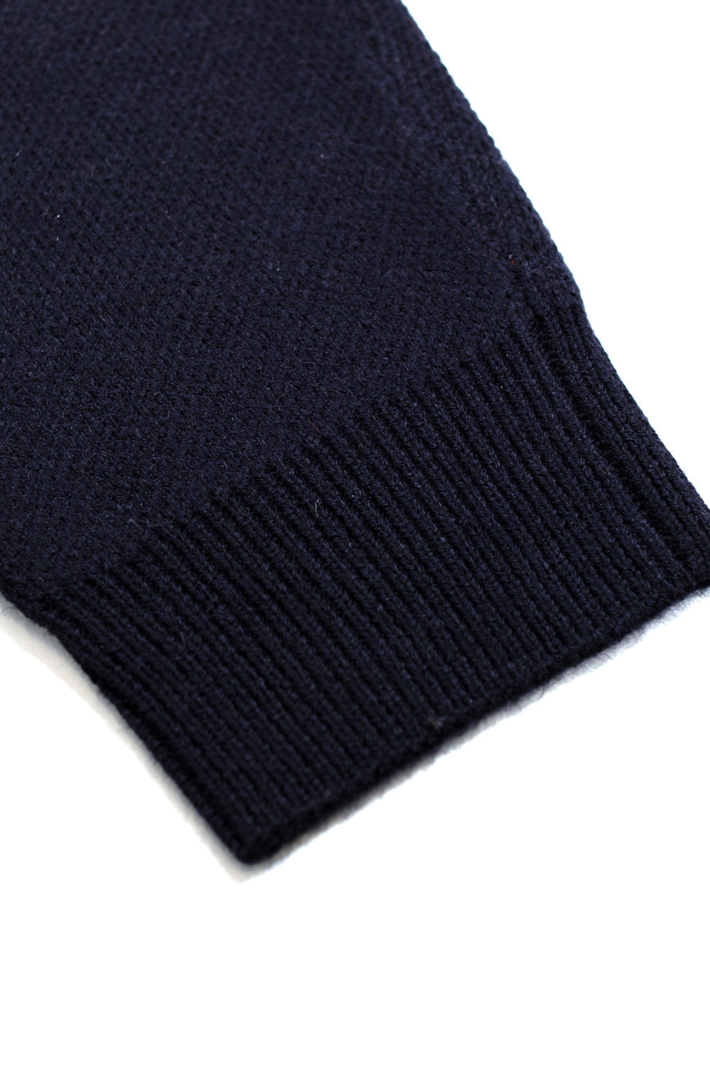 Close-up of the ribbed sleeve cuff on the Metalwood Studio Kiki Zip Knit LS Polo in navy, showing the heavyweight wool-blend knit quality and construction.
