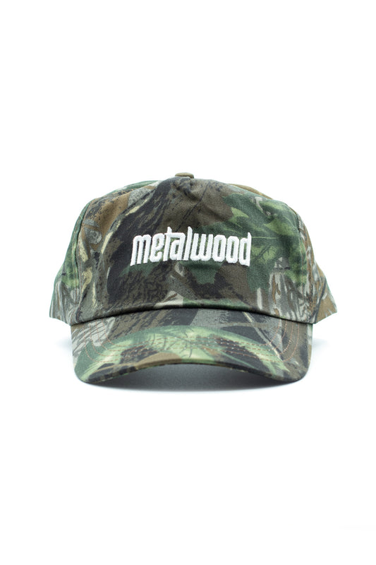 Men’s Metalwood Studio Metal Logo 5 Panel Cap in green real leaf camo, adjustable Velcro fastener, embroidered branding, and sweatband interior.