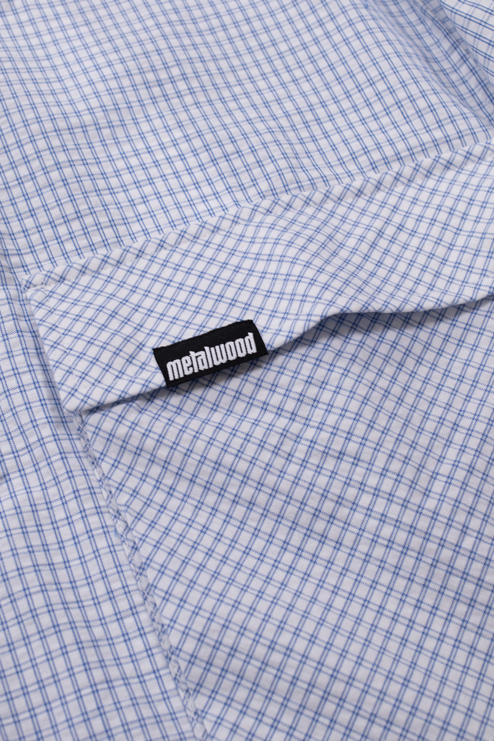 Detailed view of utility pocket construction on the White Blue tactical overshirt with signature Metalwood branding and modern workwear influences