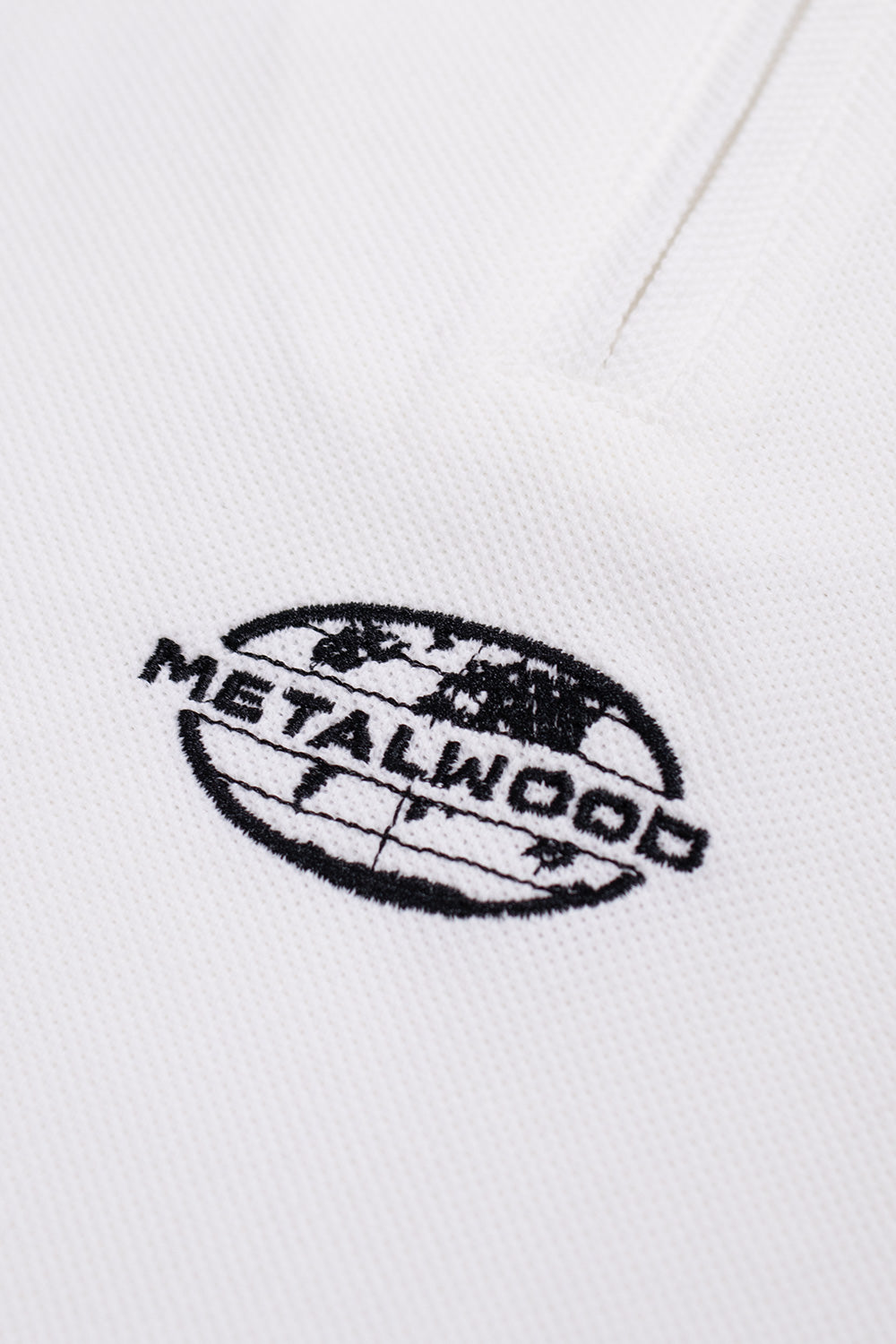 Metalwood Studio World Class Polo Zip in Weiß – sportliches Polo mit klassischem Piqué-Stoff, 1/4-Zip und coolem Logo-Emblem für einen modernen Touch.