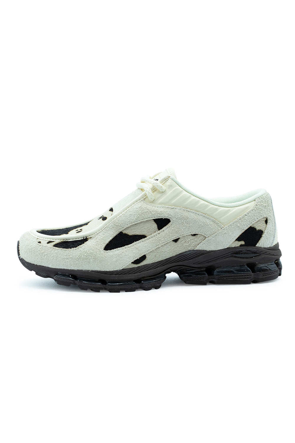 Lateral profile view of the New Balance 1890A sneaker in Angora and Rich Earth, showcasing the distinctive tailored moccasin apron toe construction, textured cow-print pony hair underlays, cut-out shaggy off-white suede overlays, ribbed collar trim, and a sculpted black ABZORB running midsole with visible ABZORB SBS heel cushioning pods.