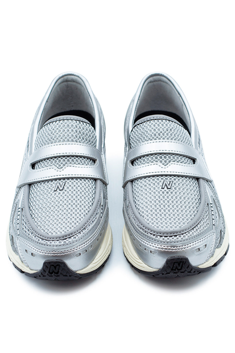 Front view of the New Balance 1906L penny loafer sneaker with perforated mesh vamp, minimalist strap detail and modern runner-inspired silhouette in silver and grey tones.