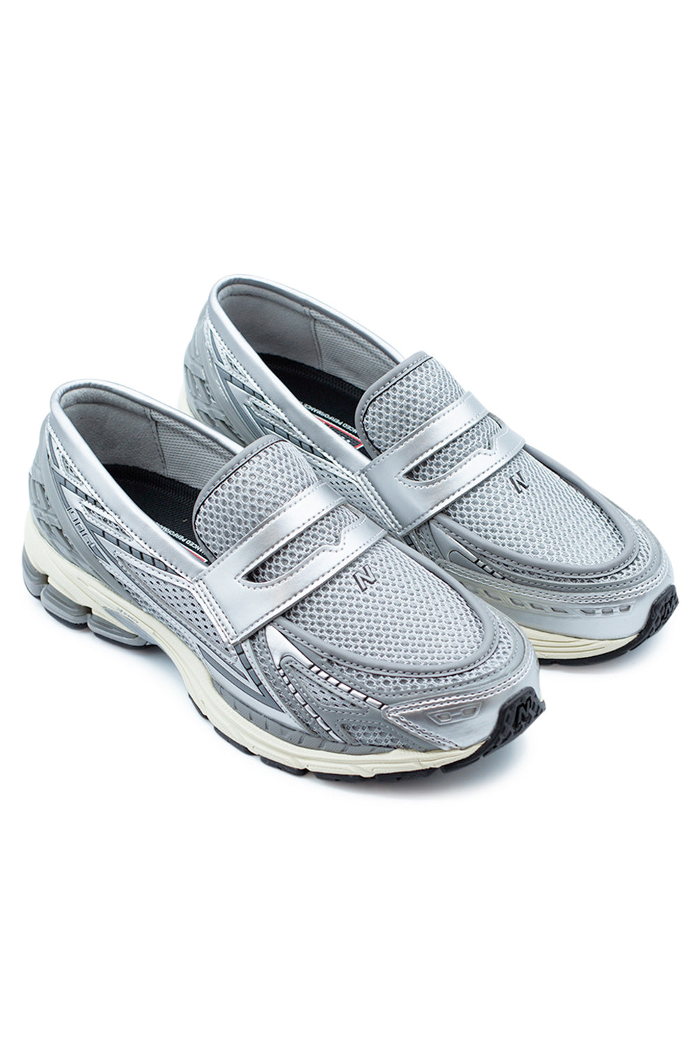 Angled view of New Balance 1906L loafers blending classic penny loafer styling with technical running shoe elements, finished in Silver and Shadow Grey with breathable mesh construction.
