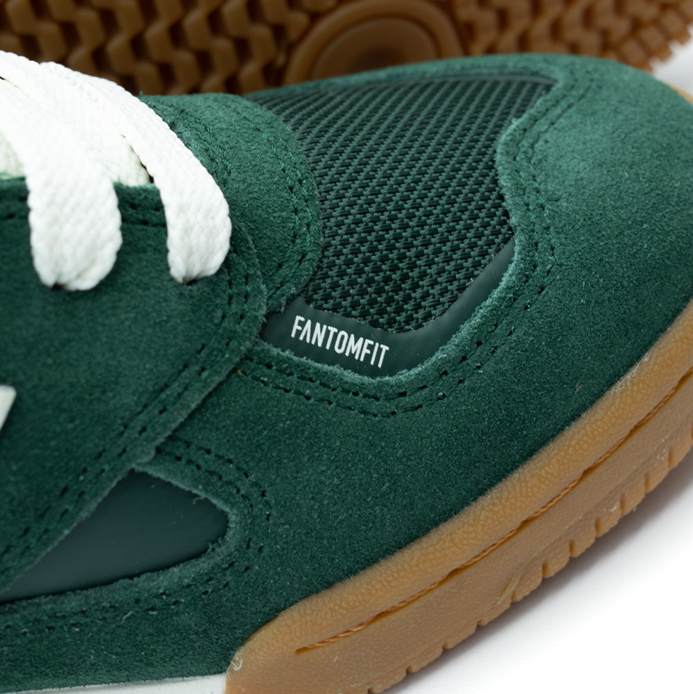Detailed macro shot of the forefoot on the New Balance Numeric Tom Knox 600, highlighting the seamless bonded FantomFit film overlay on the green mesh vamp, neat tonal suede stitching, and textured gum rubber toe bumper.