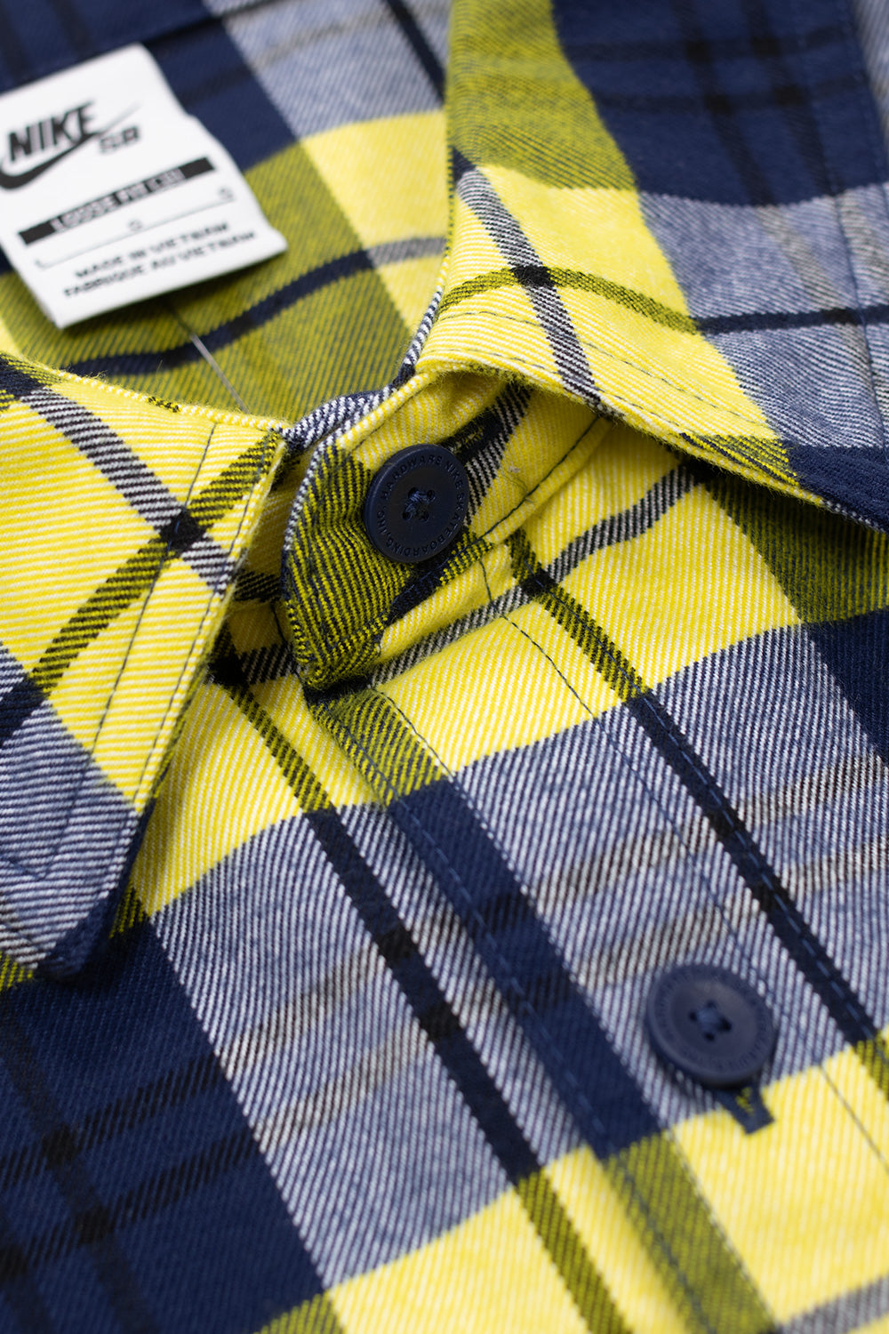 Nike SB Koston Long Sleeve Flannel Shirt Midnight Navy Speed Yellow, 90s-inspired skateboarding top featuring blue logo buttons and bold contrast design.