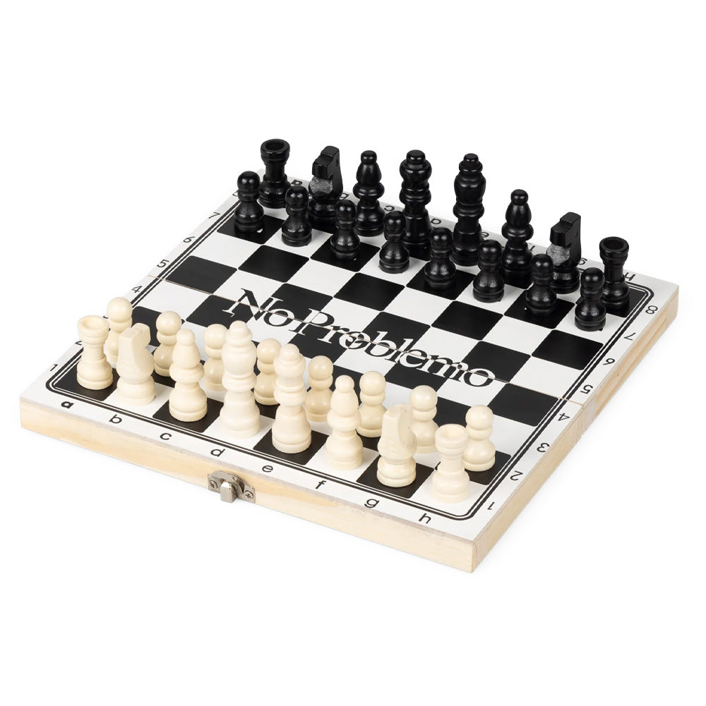 Studio view of the opened Aries No Problemo wooden travel chess board set up with carved black and natural white wooden chess pieces, showcasing the classic checkered playing field with algebraic coordinate borders, metal clasp hinge, and a bold white serif "No Problemo" slogan print split across the center files.