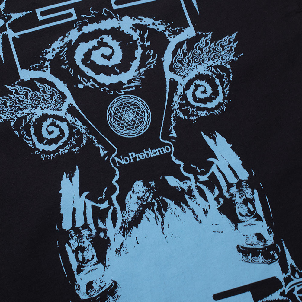 Detailed macro studio close-up of the back graphic on the black No Problemo Holy Mountain T-Shirt, highlighting the intricate cerulean-blue linework of the flame-fringed swirl eyes, sacred geometry mandala circle, and serif "No Problemo" script against soft black cotton fabric.