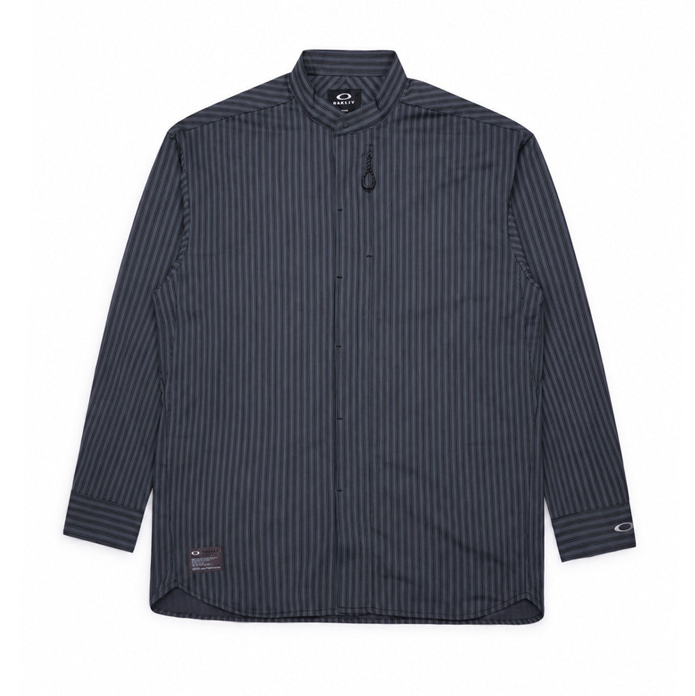 Front flat lay studio view of the Oakley FGL Fuel Long Sleeve Shirt 6.7 in Phantom, showcasing a modern technical mandarin band collar silhouette in charcoal grey with black vertical micro-stripes, concealed front snap placket, vertical zippered chest utility pocket with extended cord pull, curved hemline, and a rectangular Oakley Outdoor FGL military-spec patch stitched near the bottom right hem.