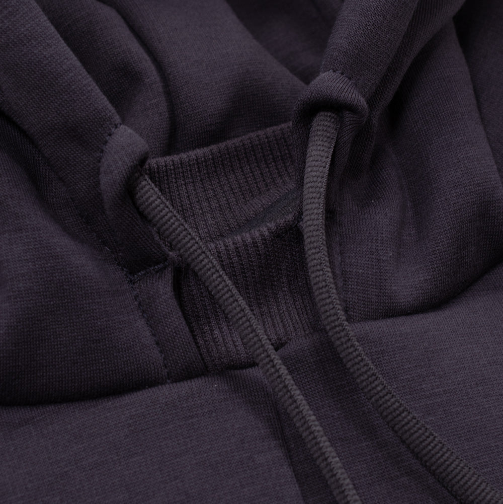Macro studio close-up of the hood opening and collar construction on the Oakley FGL Slick Fleece Hoodie in Phantom, focusing on the high-neck ribbed knit inner wind gusset, thick round tubular drawcords with dipped rubberized aglets, and the smooth jersey outer fleece surface.