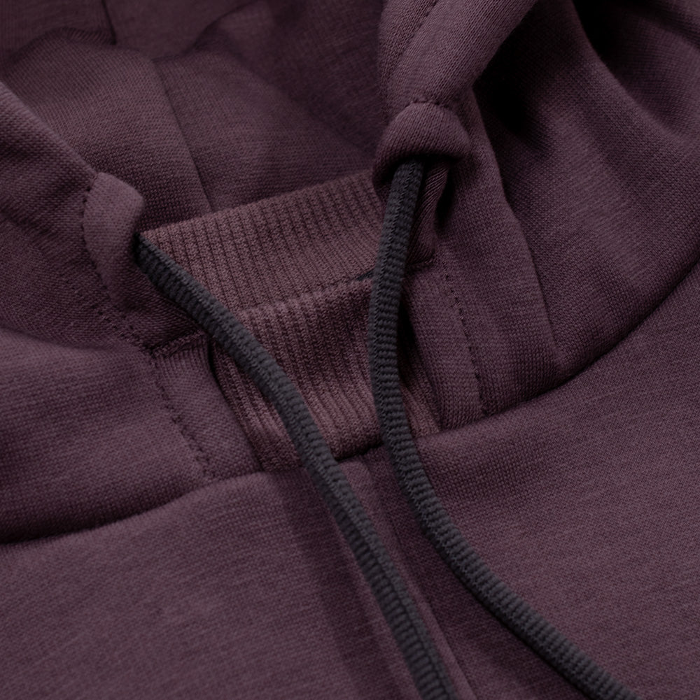 Macro studio close-up of the neckline and hood construction on the Oakley FGL Slick Fleece Hoodie, highlighting the ribbed interior collar insert, dark charcoal round drawstrings with coated aglets, and the smooth jersey outer face of the rouge purple fleece fabric.