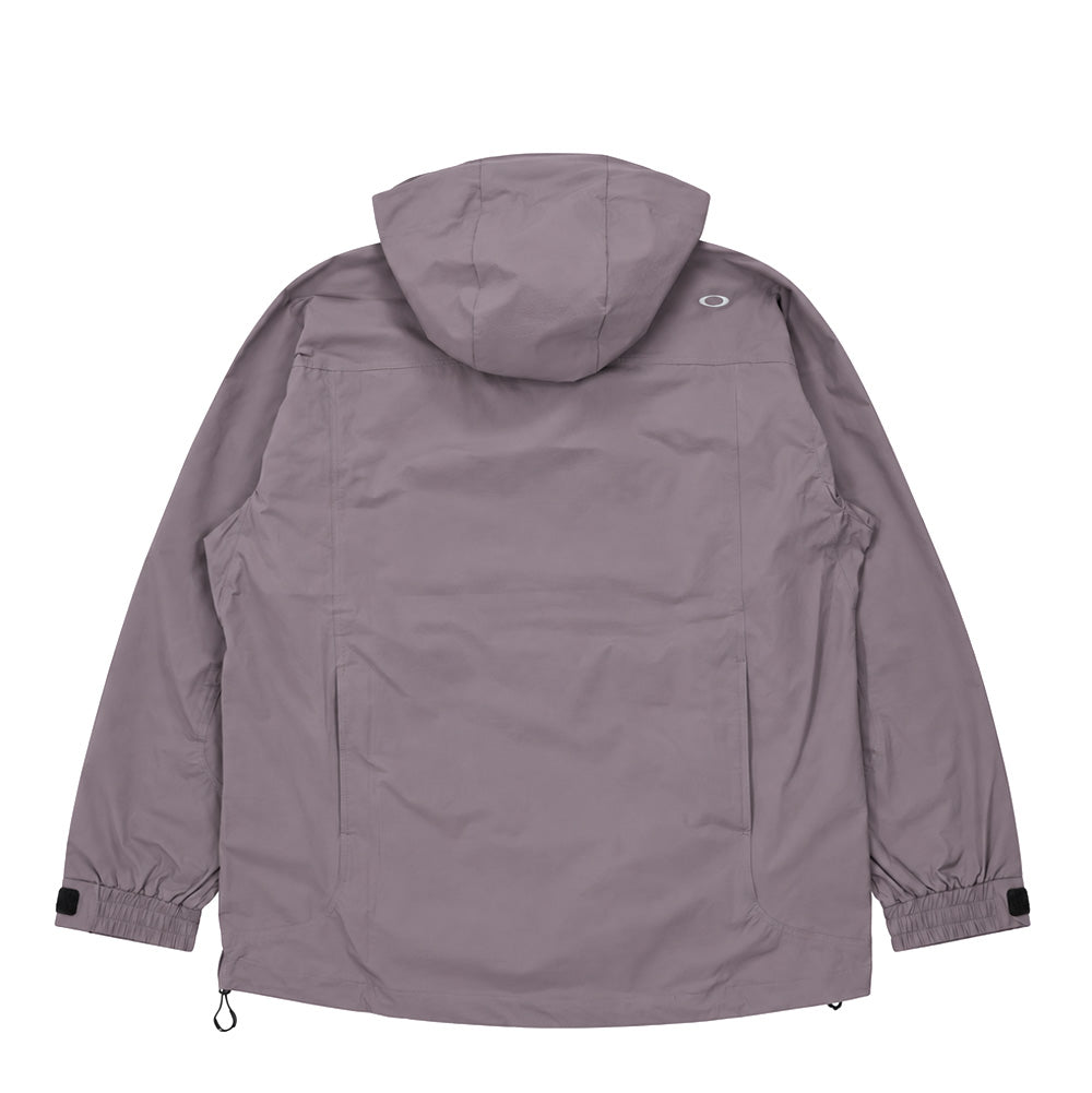Back flat lay studio perspective of the muted mauve-grey Oakley FGL Stroke Anorak 6.7, highlighting the smooth technical shell fabric drape, structured multi-panel hood, dropped shoulder seam construction, cinchable shock cord hemline, and a reflective silver metallic Oakley Ellipse logo centered on the right upper shoulder.