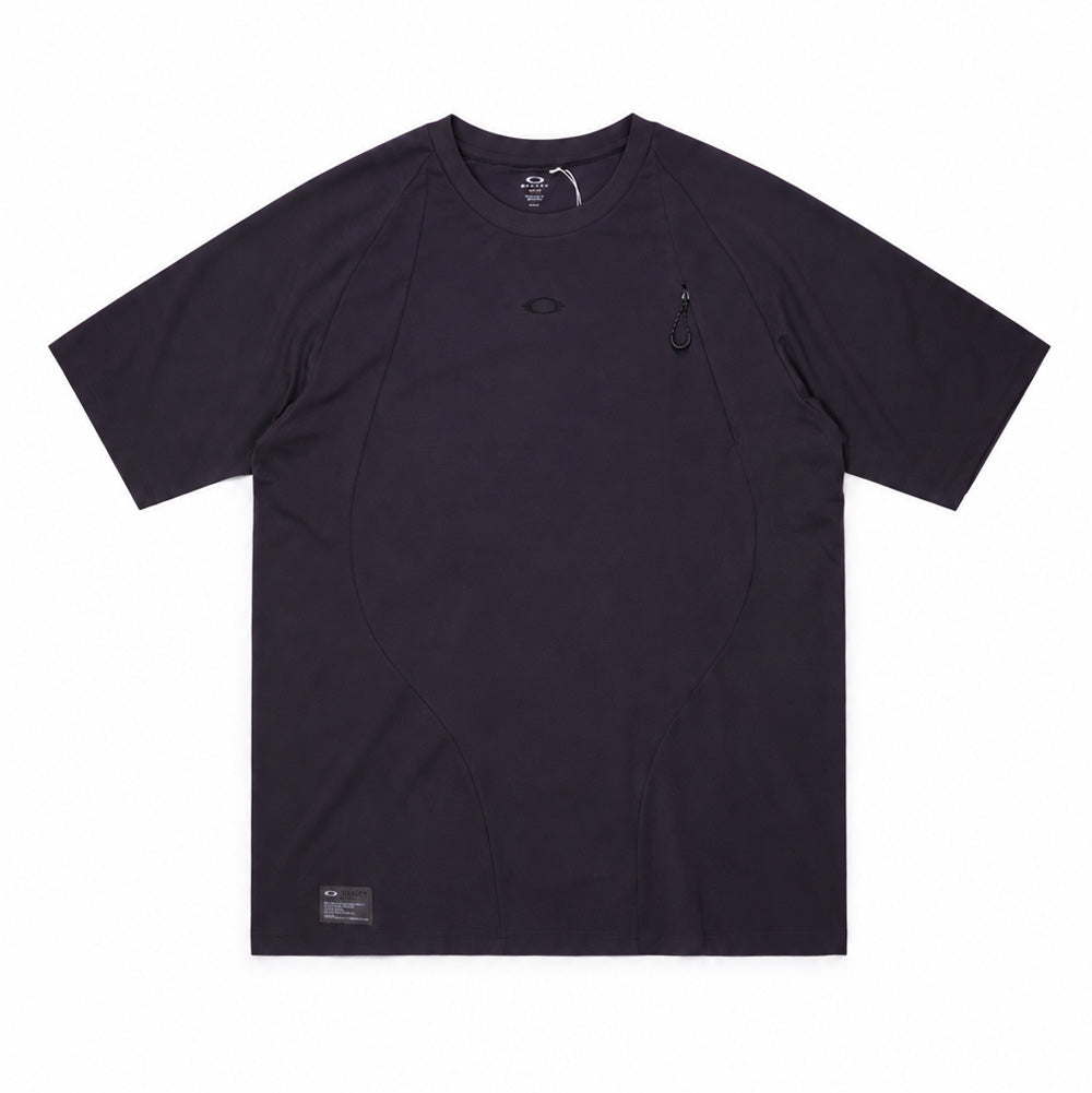 Front flat lay studio view of the Oakley FGL Union Short Sleeve Tee 6.7 in Phantom, showcasing an outdoor performance t-shirt in deep charcoal grey, designed with ergonomic curved front panelling, ribbed round collar, tonal chest logo embroidery, a vertical concealed chest zipper pocket with an ergonomic cord pull loop, and an authentic military-spec Oakley FGL woven patch at the lower right hem.