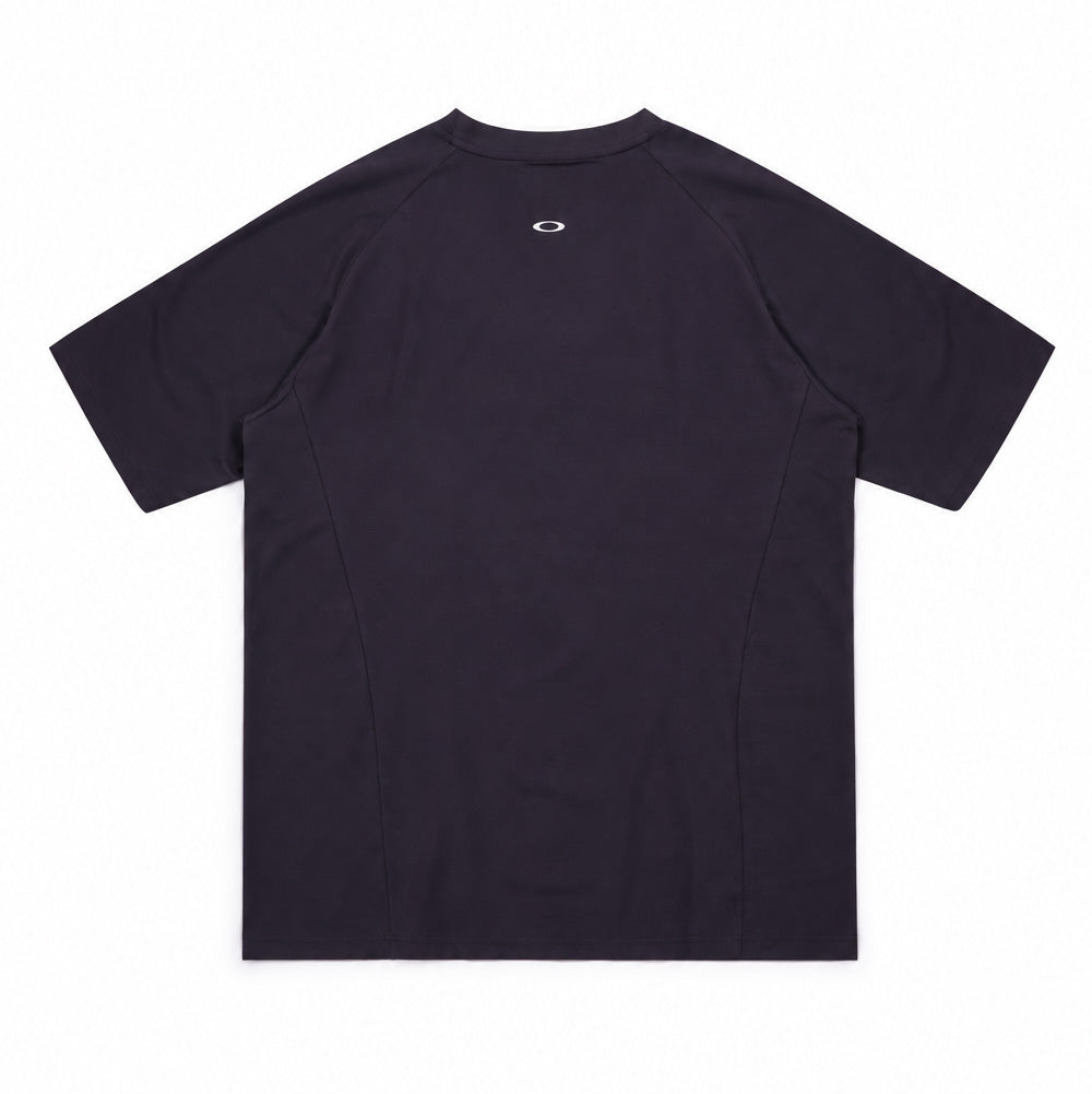 Back studio flat lay perspective of the Oakley FGL Union SS Tee 6.7 in Phantom, highlighting the raglan sleeve pattern with curved side back inserts, a dropped rear hemline, and a minimalist heat-sealed metallic silver Oakley Ellipse emblem positioned below the back neck collar.
