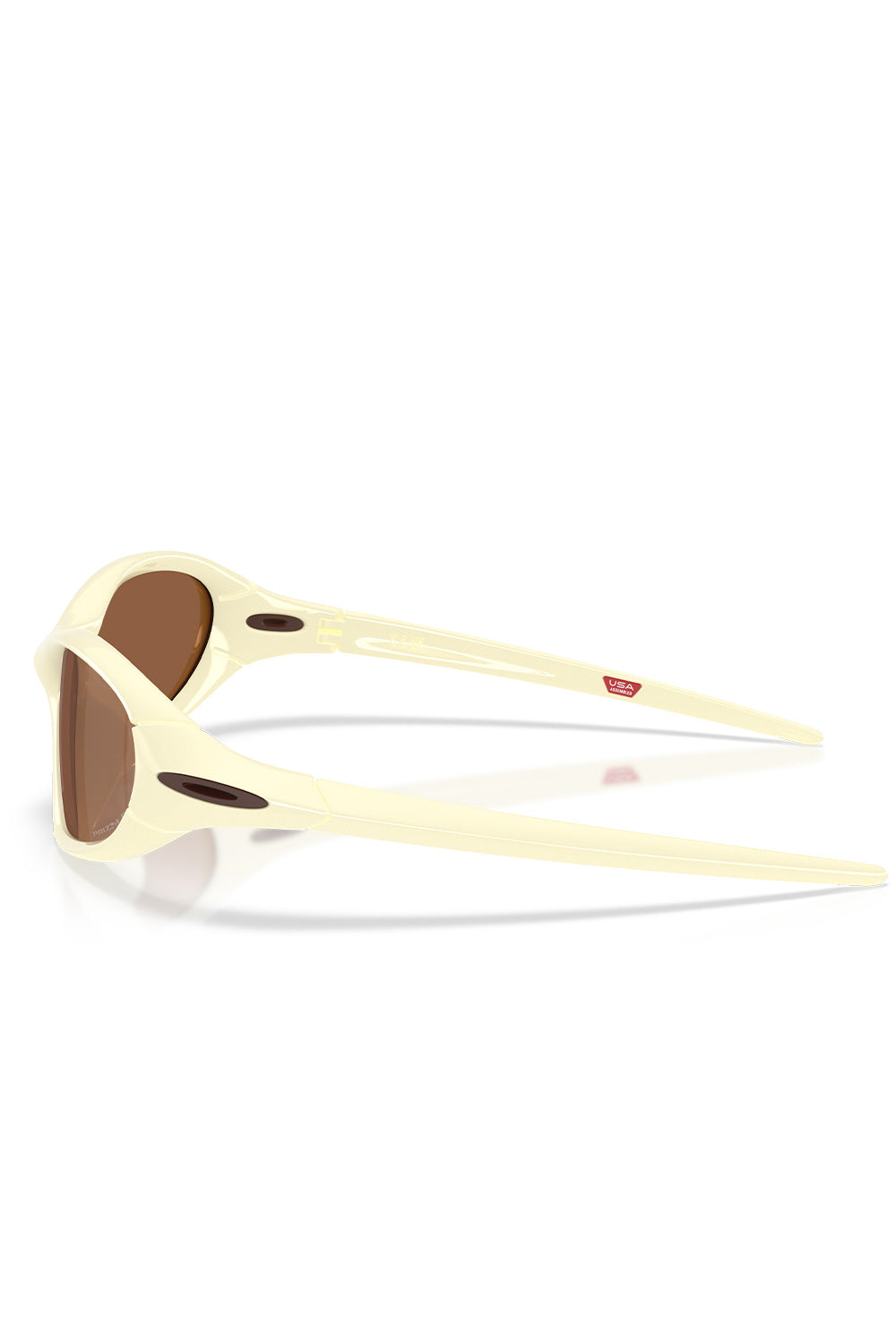 Side profile view of the Oakley Portal Jacket sunglasses in Cream, displaying the streamlined ergonomic earstems with dark oval Oakley logo inserts and a red USA Assembled badge printed on the inner arm.