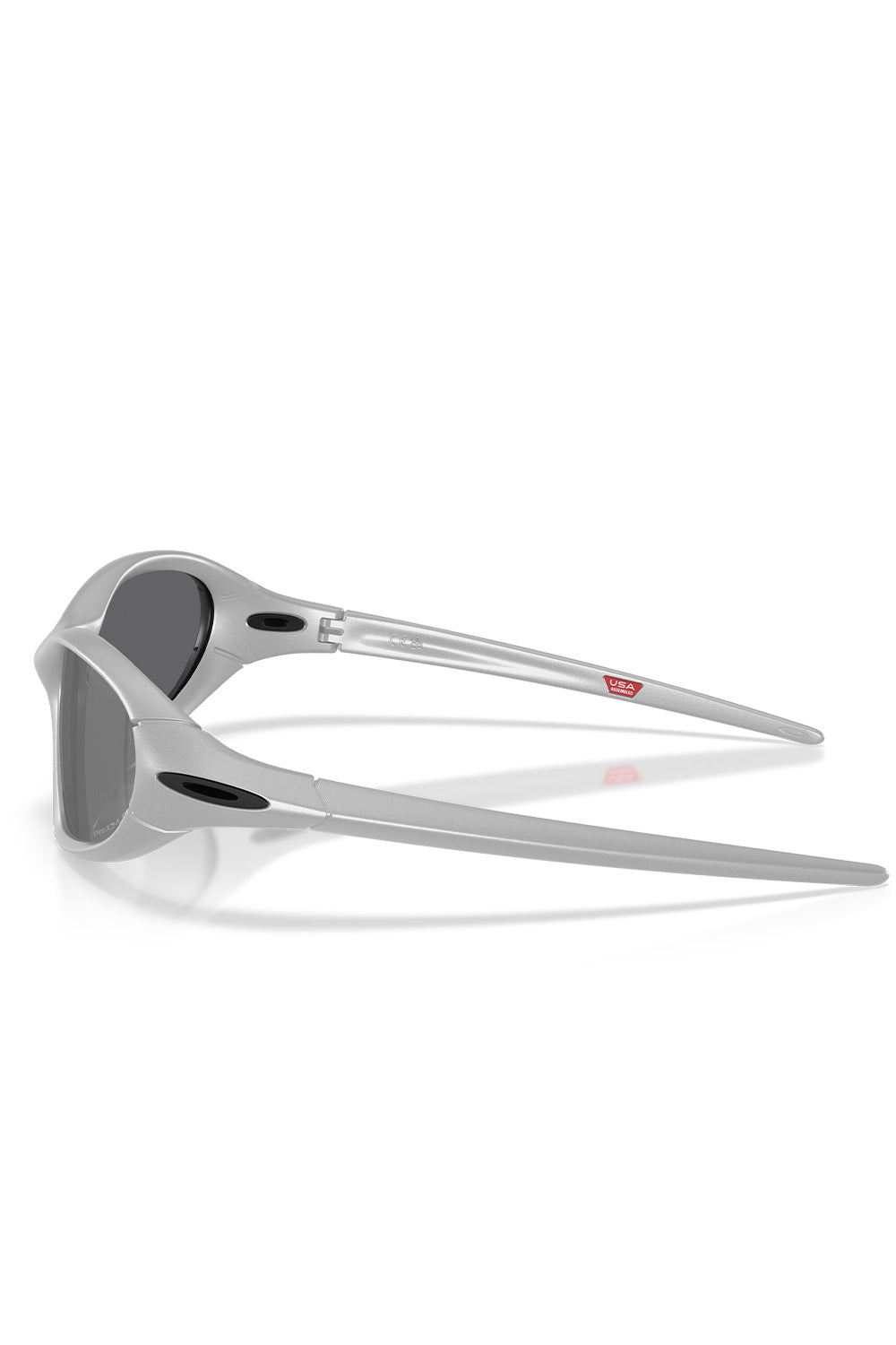 Side profile studio shot of the Oakley Portal Jacket sunglasses in metallic X Silver, displaying the sculpted ergonomic earstems with black oval Oakley ellipse icons and a red USA Assembled badge printed on the inner arm.